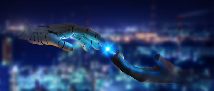 A human hand touches a robot hand.