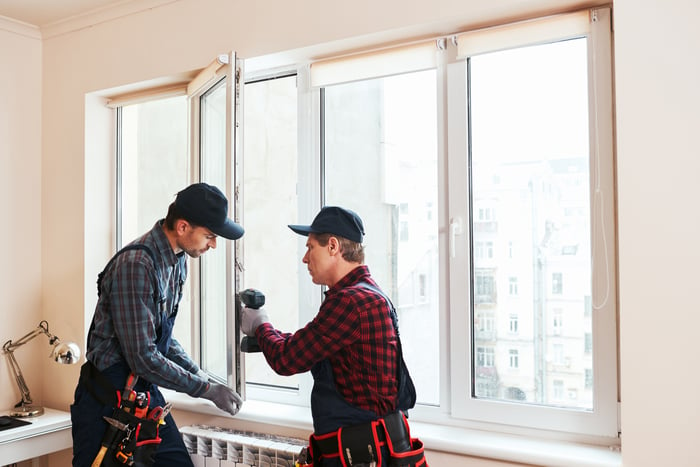 Two people installing a window.