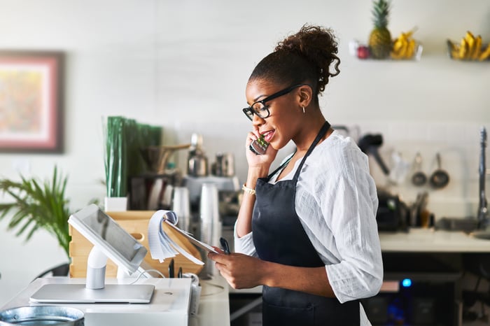 woman with clipboard talking on phone