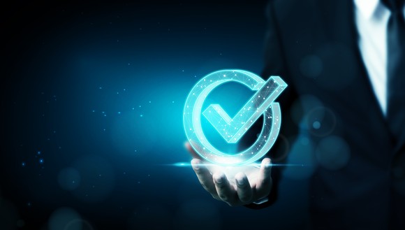 Person holding out hand with digital check mark resting on it.