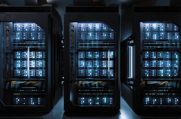 Three servers in a dark room.