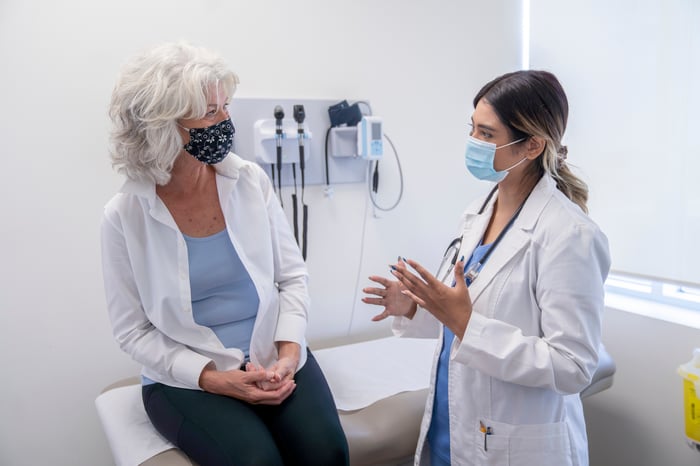 A patient and doctor speak to each other at an appointment.