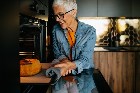 A person taking a cake out of the oven.