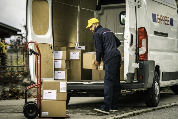 A person loading packages onto a delivery van