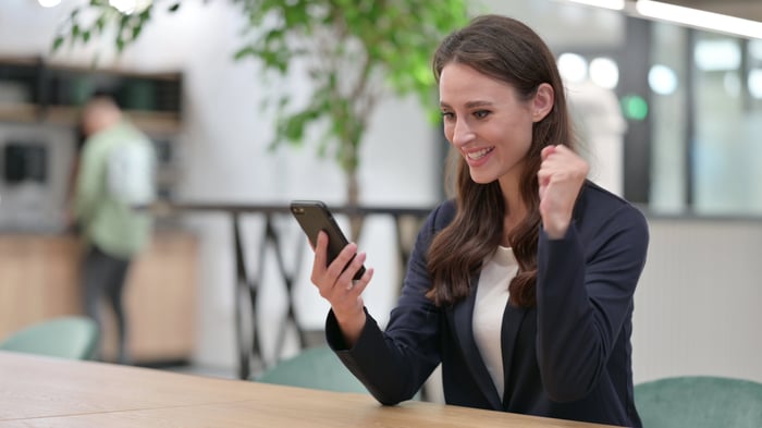 A person smiling into a phone. 