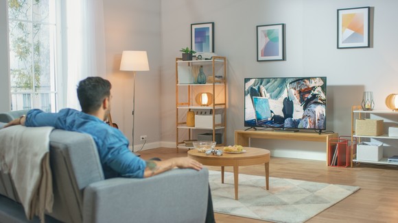 A man watching television in a living room.