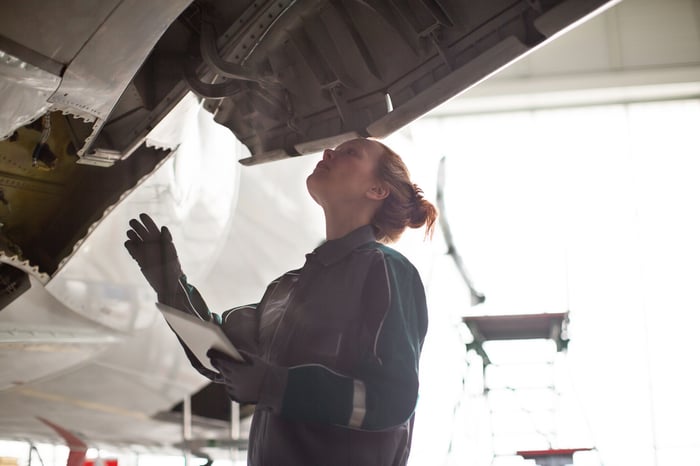 An aviation mechanic inspects an engine.