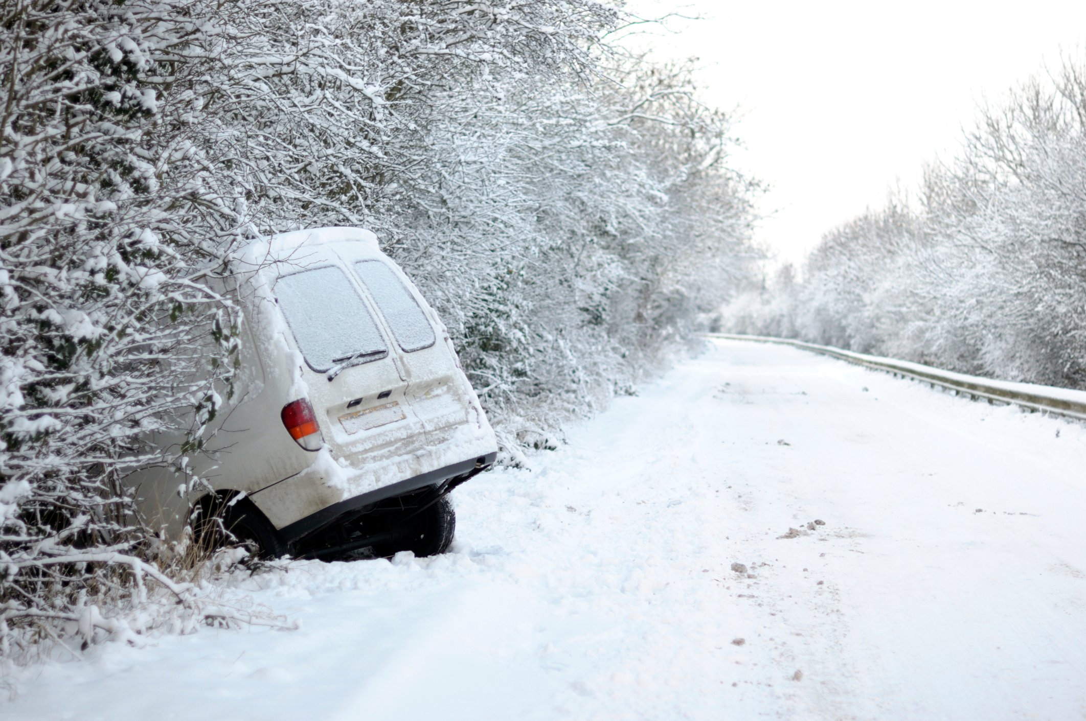 Van nose down in a ditch after skidding off road in a snowstorm.