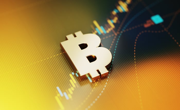 Bitcoin symbol with a chart in the background.