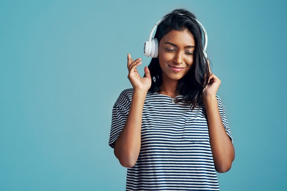 Person listening to music on headphones.