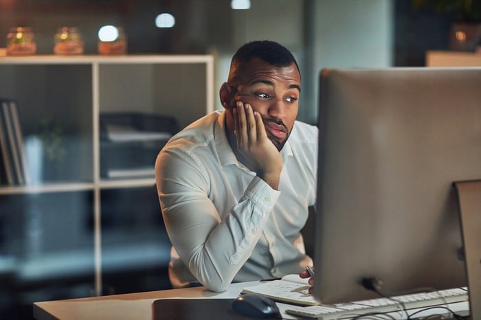 A person with a serious expression at a computer.