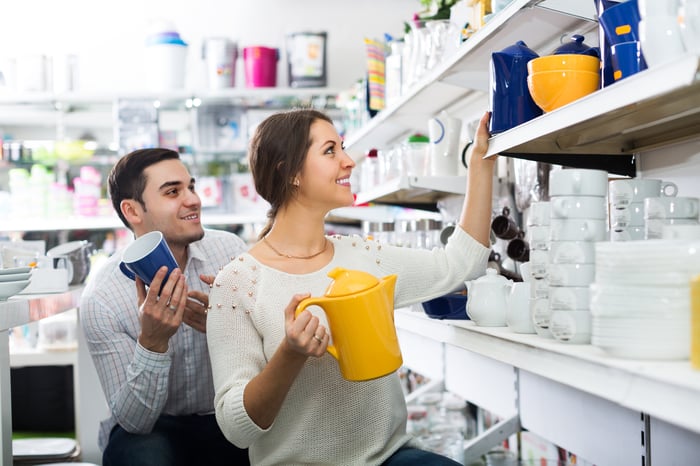 Deux personnes regardant des ustensiles de cuisine dans un magasin d'ameublement. 