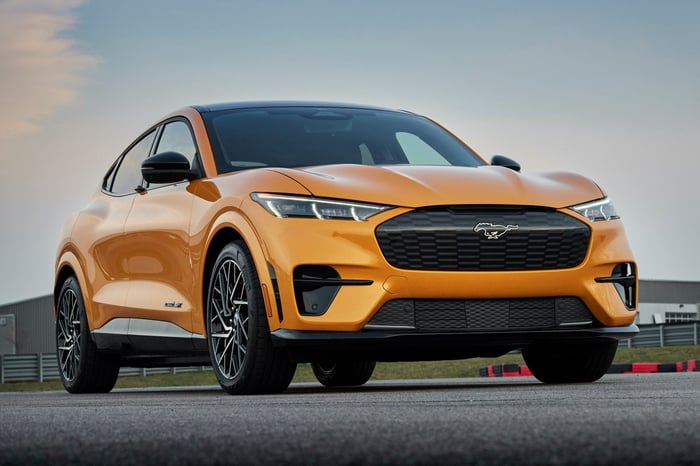 An orange Ford Mustang Mach-E electric SUV. 