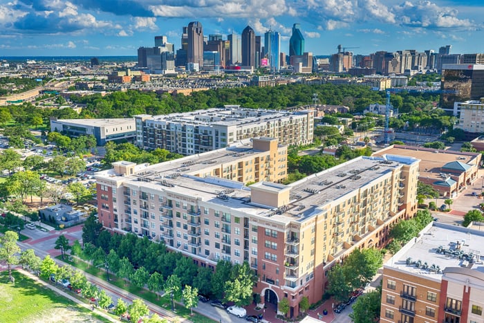 An apartment complex with the Dallas skyline in the background.