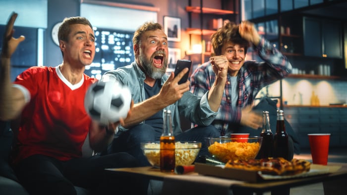 Group of sports fans watching an event on TV.