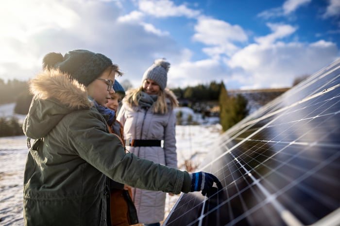 Mother explaining solar panels technology to the kids on a winter day.