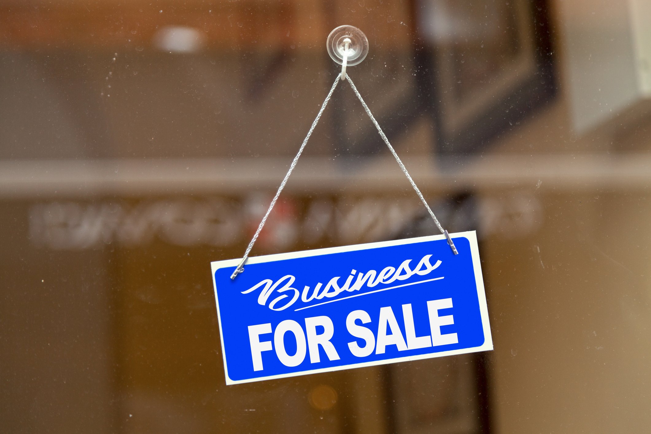 22_01_18 A business for sale sign hanging in a window _GettyImages-1090969206
