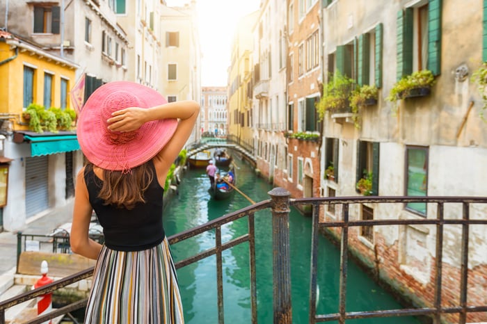 The back of a person standing on a bridge over a canal in Venice