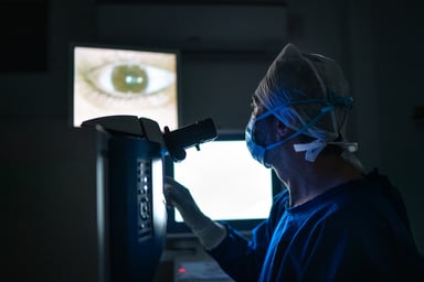 eye surgeon looks at image of eye in operating room