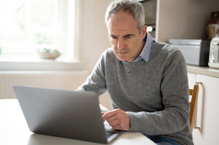 A person with a concerned expression at a laptop.