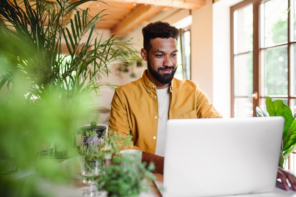 Person sitting at a desk looking at a laptop.
