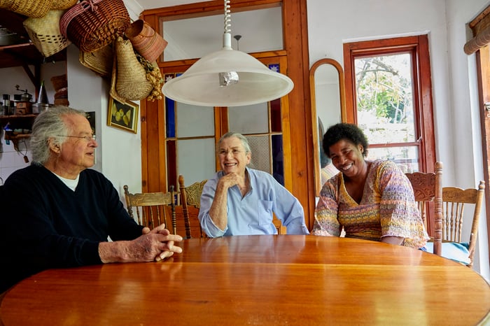 Three people siting at a table.