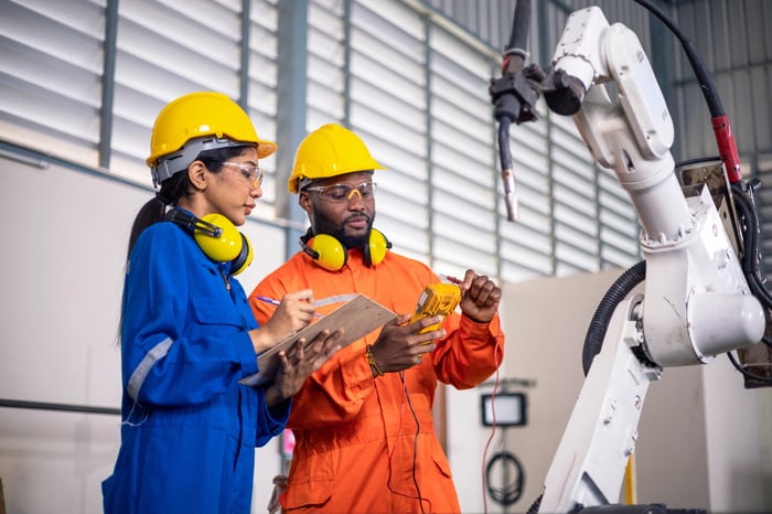 Technicians working with a robotic arm.
