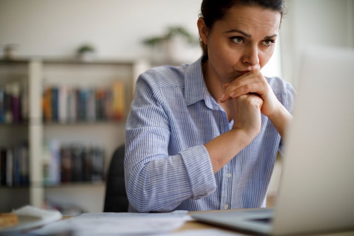 A person with a serious expression at a laptop.