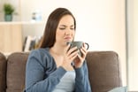 Woman drinking a bad cup of coffee -- GettyImages-918165906