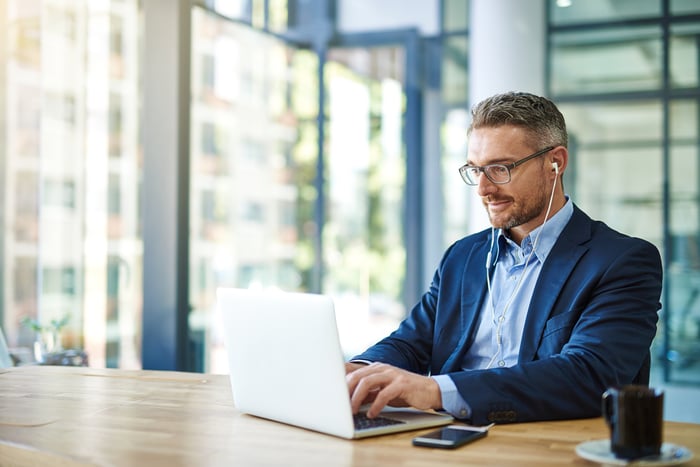 A person in professional attire at a laptop.