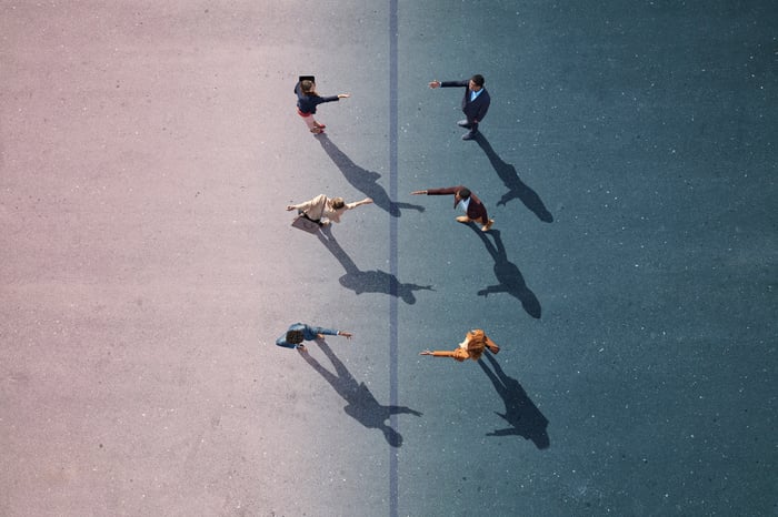Three people holding out their hands to three people facing them.