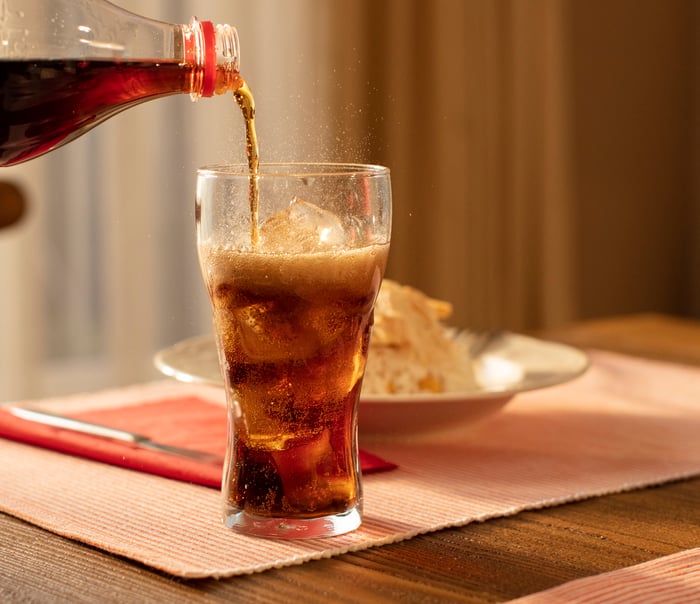 Pouring cola into a glass from bottle