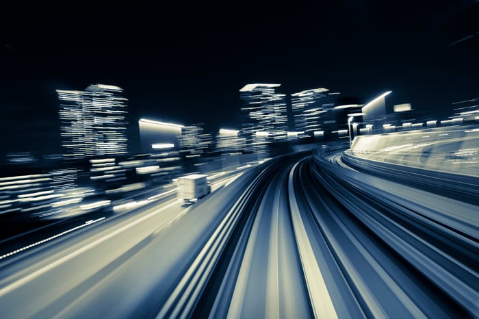 action shot of night scene of semi truck about to turn corner on city highway.