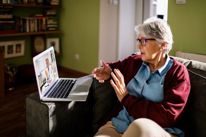 A person having a telehealth visit with a doctor on a laptop.