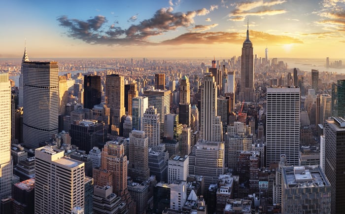 The Manhattan skyline with the sun rising in the background.