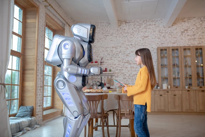 A child having fun programming a life-size robot with human characteristics