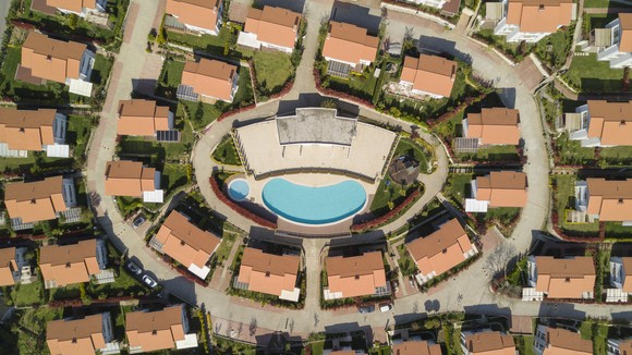 Drone shot of single-family rental community with pool in center.