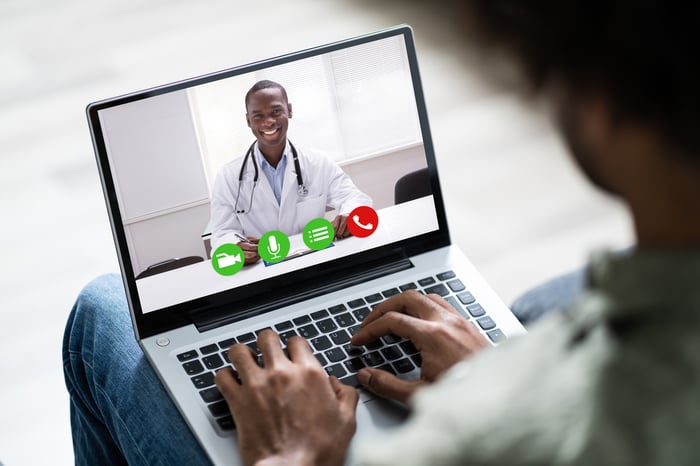 A person talking to a doctor via videoconferencing.