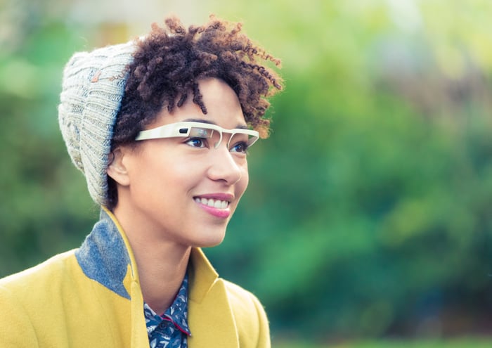 A smiling person wearing augmented reality glasses.