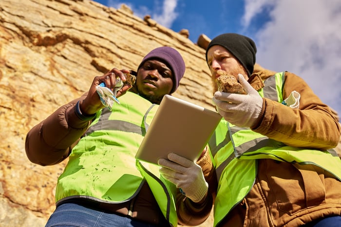 Two people looking at rocks in a mine.