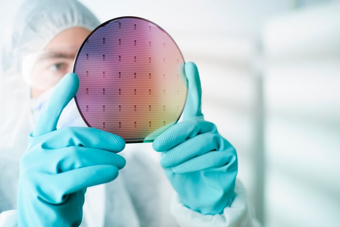 An engineer holds a silicon wafer.