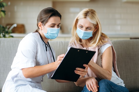 Physician and patient reviewing clipboard.