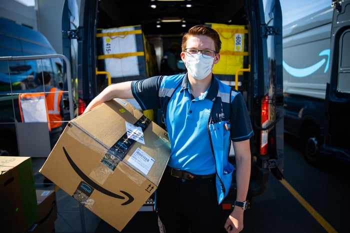 An Amazon delivery worker holding a package.