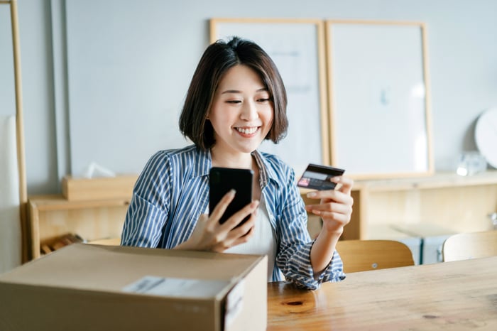 An online shopper makes  a purchase on a smartphone with a credit card.