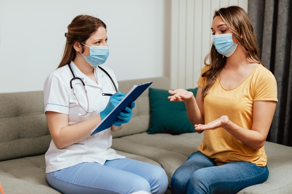 A patient and medical professional speak with each other at an appointment.