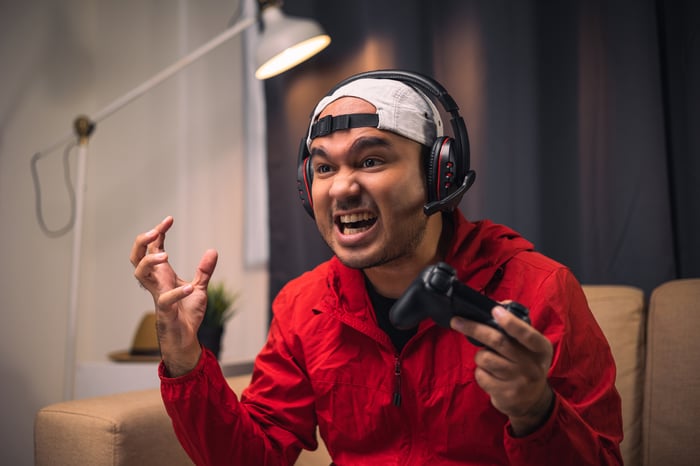 A gamer reacts in frustration while playing a video game.