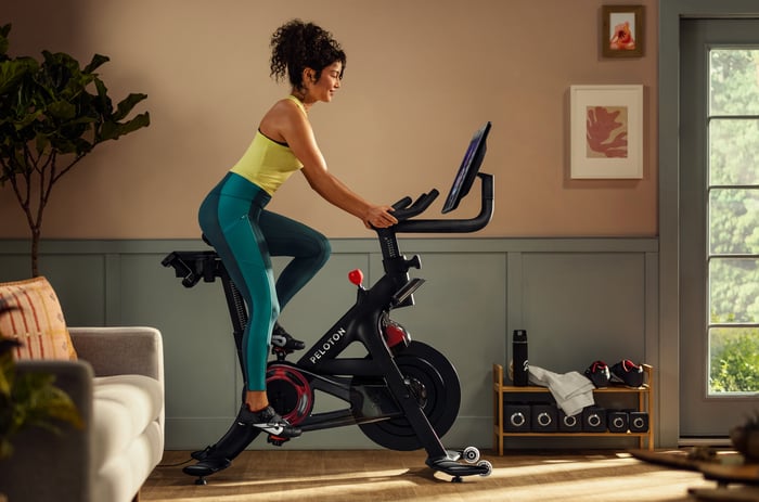 A person is riding a Peloton Bike+ exercise bike.