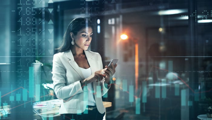 An investor trades stocks on a phone.