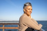 Senior woman looking out over water -- GettyImages-1316488076