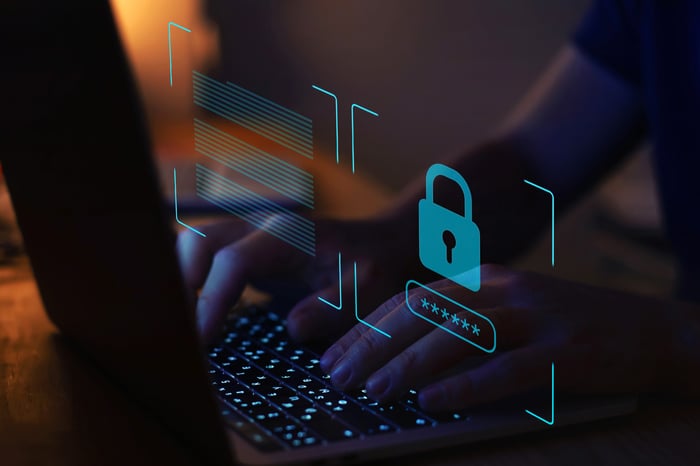 A person typing on a keyboard with an image of a lock overlaid.